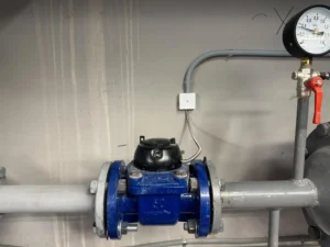 Bomba de pressurização de água instalada em ambiente industrial, mostrando componentes e manômetros para controle de pressão.