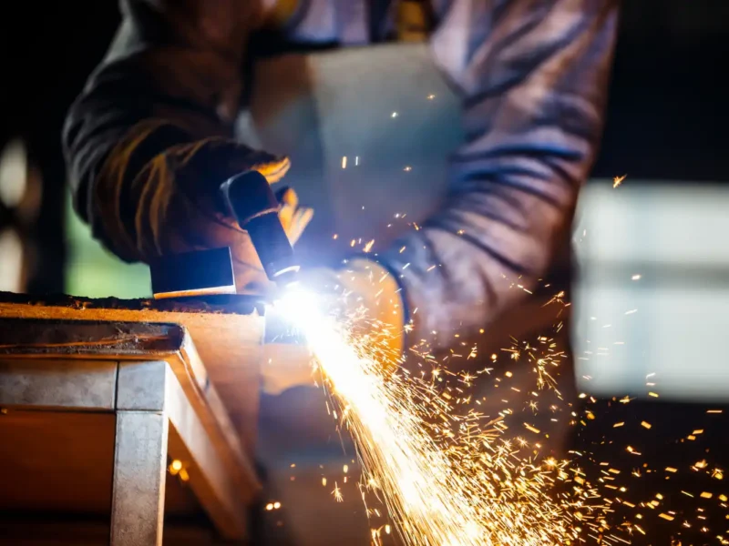 Profissional de metalurgia utilizando automação na fabricação de componentes metálicos, destacando a revolução nos processos de metalurgia com tecnologia avançada.
