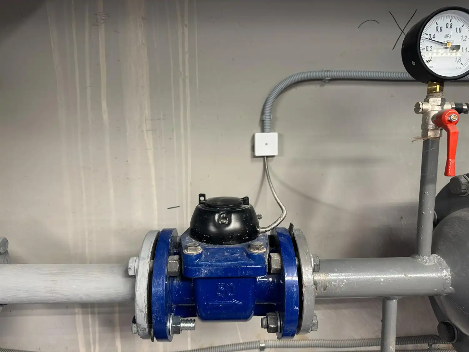 Bomba de pressurização de água instalada em ambiente industrial, mostrando componentes e manômetros para controle de pressão.